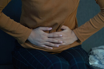 Health Awareness: Individual Holding Stomach in Discomfort