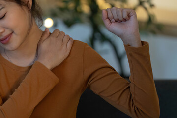 Health Awareness. Young woman experiencing shoulder discomfort at home.