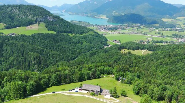 Aerial rises above lush vast green forest and lake in Austrian Alps, drone daylight view at Laimeralm Mountain I Lake Wolfgangsee