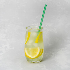 Homemade lemonade with ice in a glass on a gray background. Refreshing drink