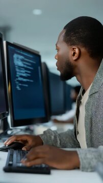 A man is sitting in front of a computer with a keyboard and a monitor