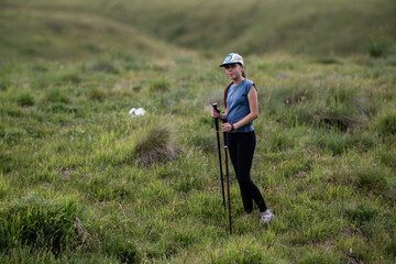 Young woman hiking in lush green landscape