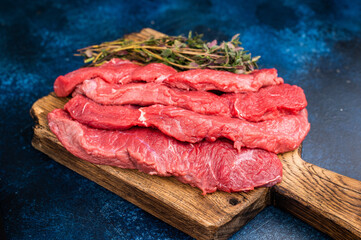 Beautifully sliced raw buffalo meat on a rustic platter, showcasing its appealing color and...
