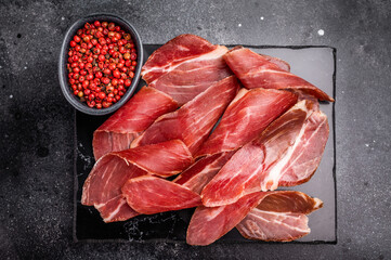 Sliced prsut prshut, Balkan cured pork meat ham. black background. top view
