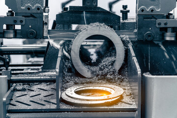 The band saw cutting machine cutting the metal shaft parts with coolant method. The machine tool...