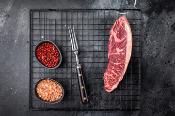 Raw beef picanha steak, featuring a thick layer of fat that adds flavor during cooking. black...
