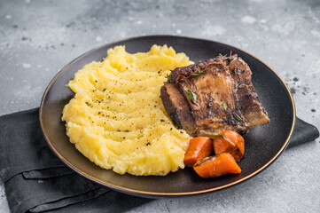 Slow cooked Beef short ribs, perfectly cooked and glazed with a rich barbecue sauce. grey background. top view