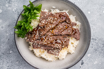 Delectable yakiniku feast, featuring a variety of marbled beef cuts and rice. A culinary journey that captures the essence of Japanese grilling traditions. grey background. top view