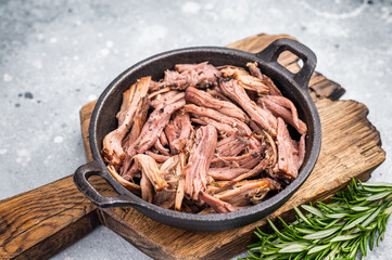Savory pulled beef brisket served in a skillet, dipping  creating an appealing and mouthwatering...