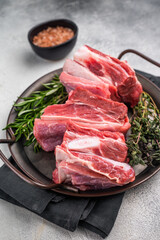 Raw lamb Riblets, fresh mutton meat with rib bone. grey background. top view