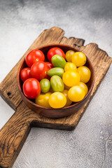 Fresh small red, green and yellow cherry tomatoes assortment, mini organic cocktail tomate mix. white background. top view
