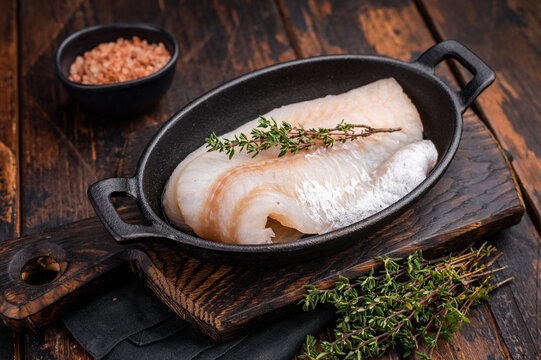 Pristine raw cod fillet, waiting to be marinated and cooked to perfection for a delightful dining experience. wooden background. top view