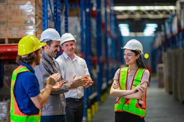Warehouse workers celebrating success and recognizing team effort. Positive office culture and team...