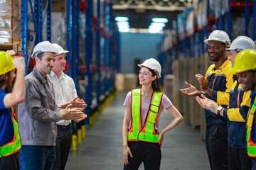 Warehouse employees applaud female team member with smiles and pride. Strong visual for HR...