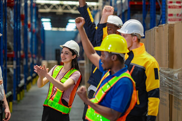 Confident woman employee in safety gear stands at the center while coworkers clap and cheer, celebrating her recent promotion or workplace achievement.