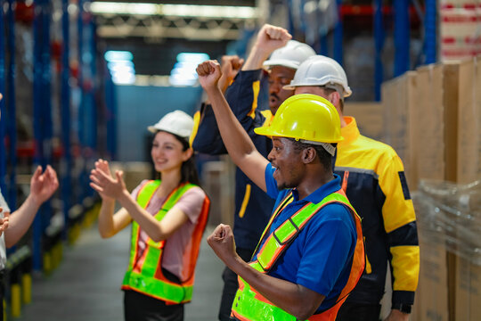 A diverse team of workers enjoy a spontaneous dance of joy after finishing a task, showing happiness and unity in the workplace. Focus on A Black employee.