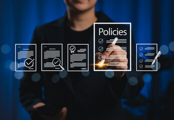 Policy documentation and compliance concept. Businesswoman reviews digital document Policies with icons, checklists, certifications, and financial detail. policy management, regulatory compliance,