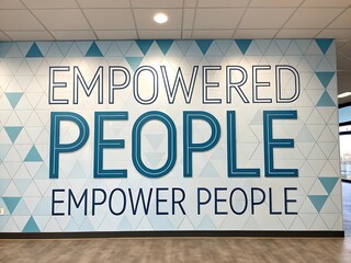 Inspiring wall mural featuring the motivational quote empowered people empower people in large bold letters