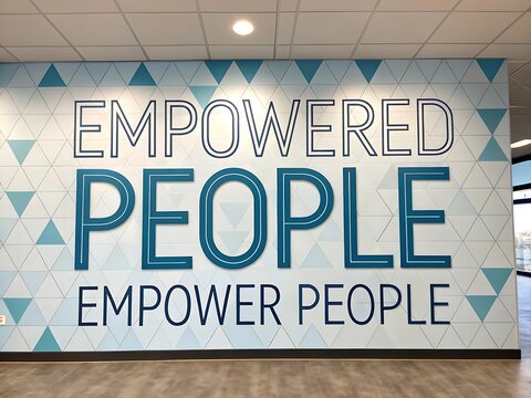 Inspiring wall mural featuring the motivational quote empowered people empower people in large bold letters