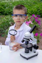 A child examines water using a magnifying glass