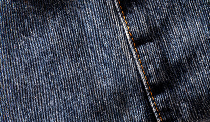 Close up  photo fabric. Denim blue with orange stitching.