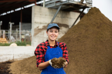 During days work in cowshed, female employee works with manure, picks up eco-friendly fertilizer...