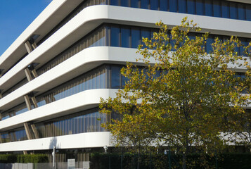 A new corporate building with a modern design, many windows, and a white facade near Geneva, Switzerland