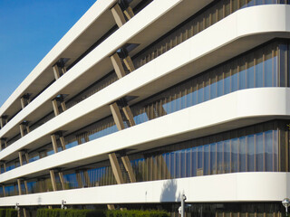 Perspective view of an impressive new corporate building with a modern design, numerous windows, and a white facade near Geneva, Switzerland