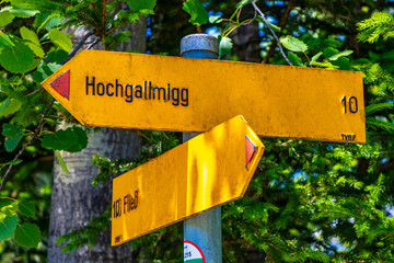 Yellow arrow location and hiking sign direction in Tyrol Austria.