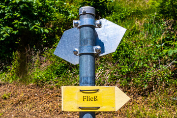 Yellow arrow location and hiking sign direction in Tyrol Austria.