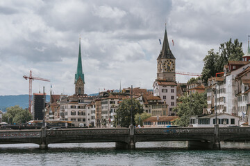 St. Peter church and fraumunster towering over limmatquai in zurich, switzerland