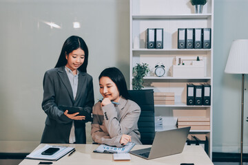 Entrepreneur Asian businessman and businesswoman discussing new business project in tablet in modern Meeting In Modern Office, Asian business casual concept.