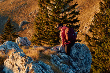 A female mountaineer, equipped with professional gear, enjoys the thrill of her climb as she...