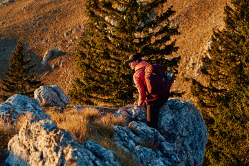 A female mountaineer, equipped with professional gear, enjoys the thrill of her climb as she...
