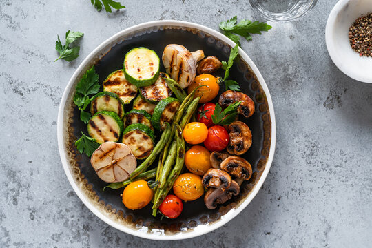 Vegan food, plate with grilled green bean, zucchini, mushrooms, cherry tomatoes, plant based food