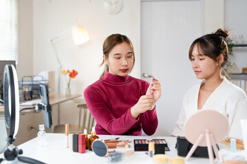 Beautiful young woman fashion vlogger or blogger reviewing recording video beauty products to share...