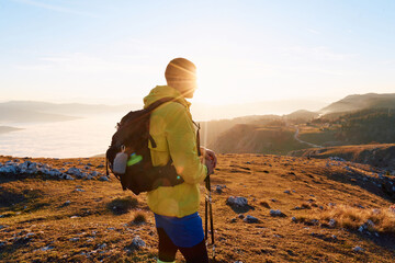 An extreme mountaineer, equipped with professional gear, pushes towards the peak of the mountain at...