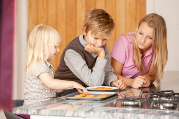Family Life, Fresh Cookies. A group of young siblings enjoying some freshly baked bisuits in the...
