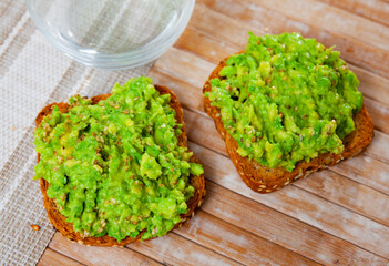 Simple snack made at home according to Mexican recipe sandwiches with guacamole paste. Hearty,...