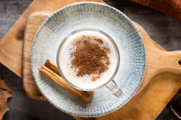 Maple Latte with Cinnamon in Glass Mug on wooden table