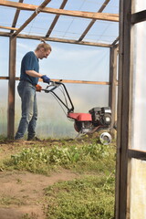 Young man engaged in household chores and small-scale rural farming, tending to his garden with...