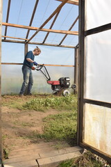 Young man engaged in household chores and small-scale rural farming, tending to his garden with...