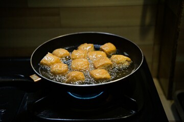 Close up frying tofu in a pan in the kitchen.