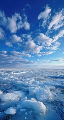 Obraz premium Ice floes on a vast expanse of blue water under a vibrant sky filled with puffy clouds