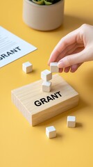 Hand Stacking Cubes on 'Grant' Block, Funding Concept funding concept hand application finance idea