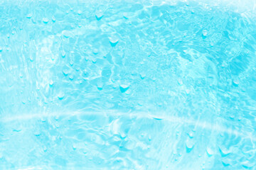 Blue water with ripples on the surface. Defocus blurred transparent blue colored clear calm water surface texture with splashes and bubbles. Water waves with shining pattern texture background.