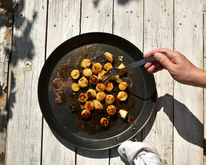 Woman hand with fork while fried bananas preparation process. 