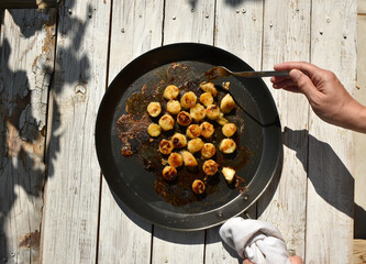 Woman hand with fork while fried bananas preparation process. 