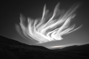 Dramatic black and white landscape photo featuring swirling clouds over rolling hills.