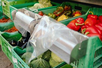 Close up of vegetables and greens in boxes and polyethylene bag on the local Farmers market....